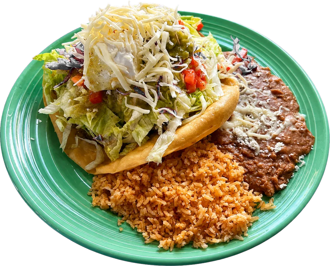 Tostada supreme plate stacked with beans, meat, lettuce, cheese and crema